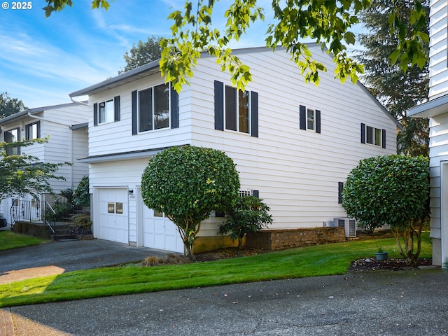 view of front of house with central AC unit and a garage