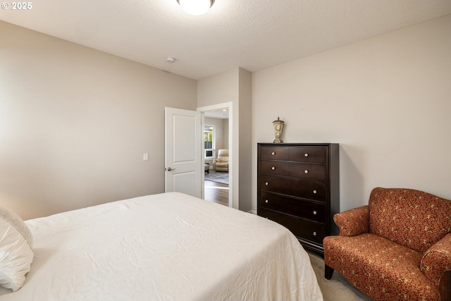 bedroom featuring a textured ceiling and carpet floors