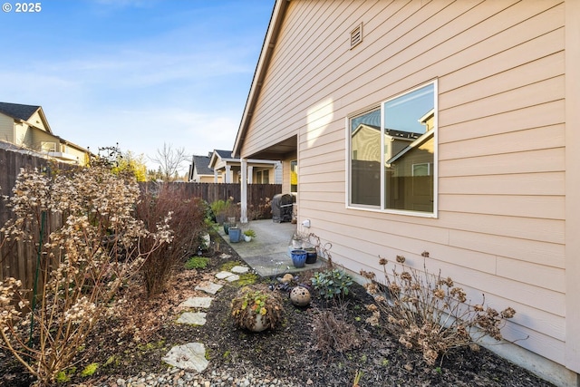 view of side of home with a patio area and a fenced backyard