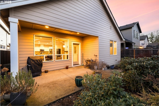 rear view of house featuring a patio and fence