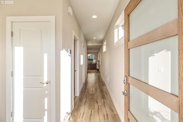 hallway with recessed lighting, light wood-style flooring, and baseboards