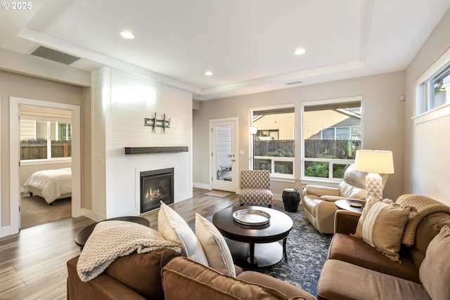 living area with a fireplace, wood finished floors, visible vents, and recessed lighting