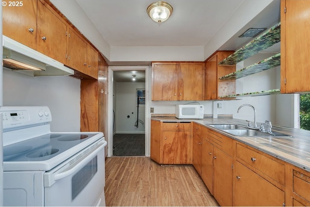 kitchen with sink, white appliances, and light hardwood / wood-style flooring