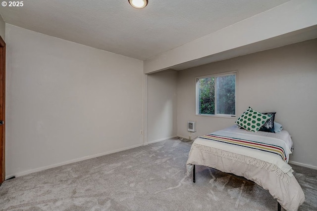 bedroom with a textured ceiling and light carpet