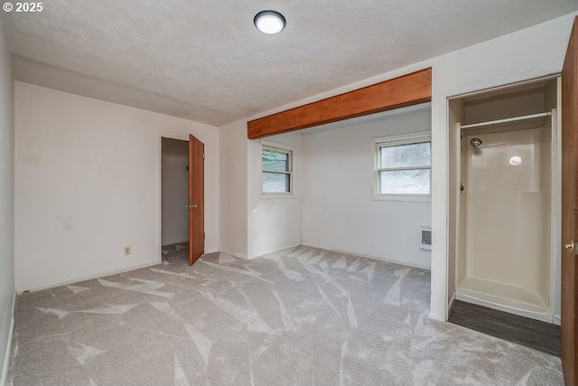 unfurnished bedroom with a textured ceiling and light carpet