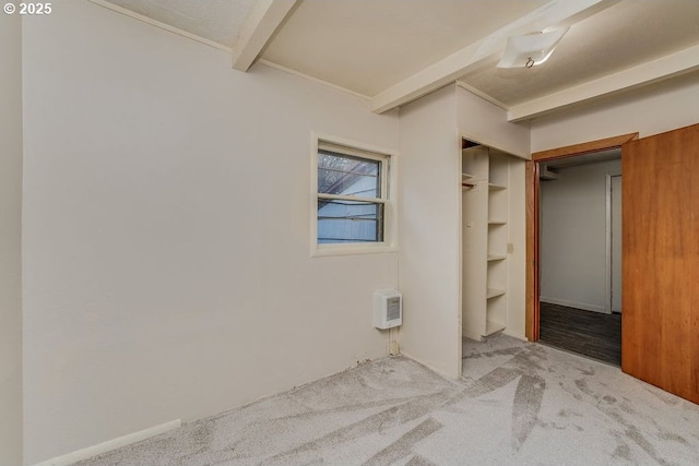 unfurnished bedroom featuring light colored carpet, a closet, and beam ceiling