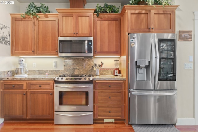 2610 Crowther Dr, Eugene, OR 97404 - kitchen with stainless steel appliances, light wood-style flooring, and decorative backsplash