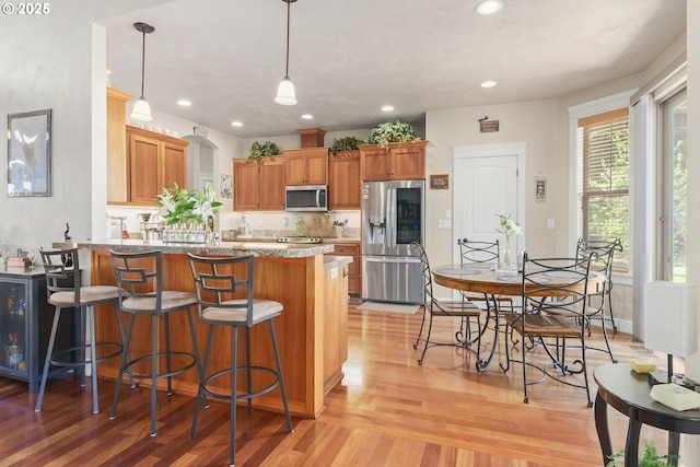 2610 Crowther Dr, Eugene, OR 97404 - kitchen with appliances with stainless steel finishes, light wood-style flooring, a peninsula, brown cabinets, and recessed lighting