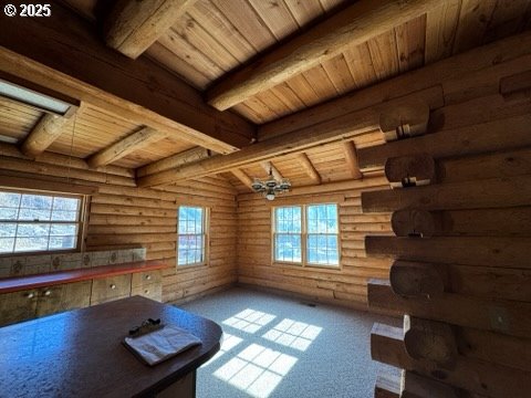 unfurnished office with wooden ceiling, plenty of natural light, and beamed ceiling