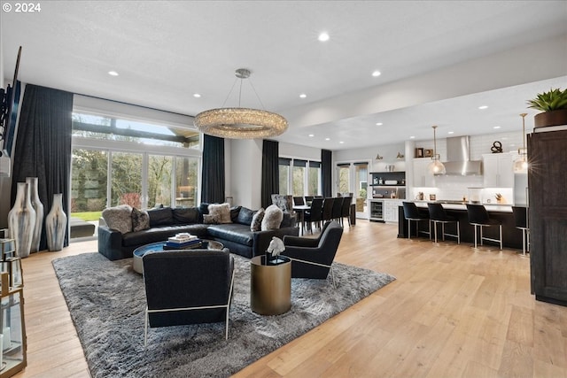 living area with recessed lighting, light wood-style flooring, and beverage cooler
