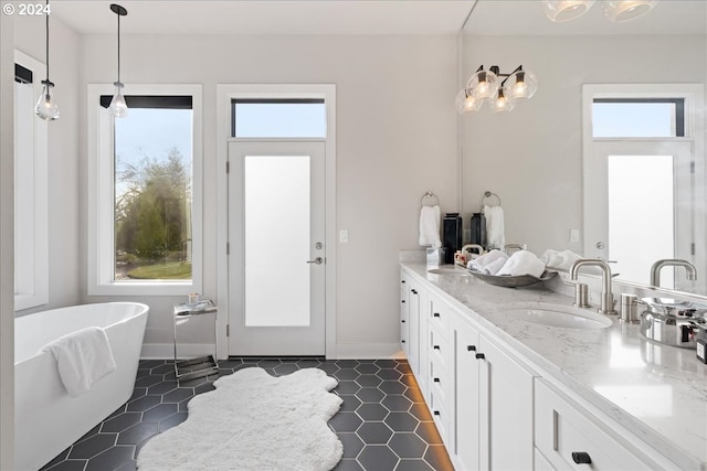bathroom featuring vanity, tile patterned floors, a healthy amount of sunlight, and a soaking tub