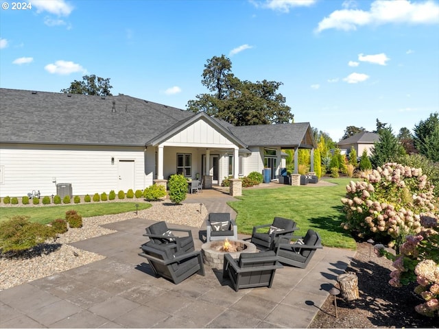 back of property featuring a fire pit, central AC unit, board and batten siding, a patio area, and a lawn