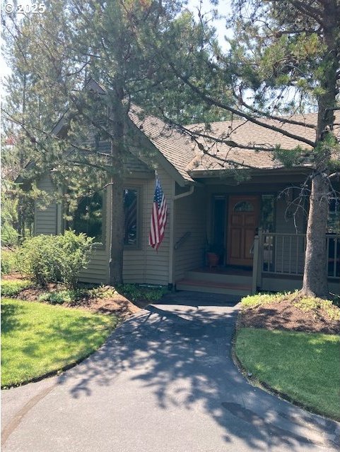 view of front of house with aphalt driveway, an attached carport, and a porch