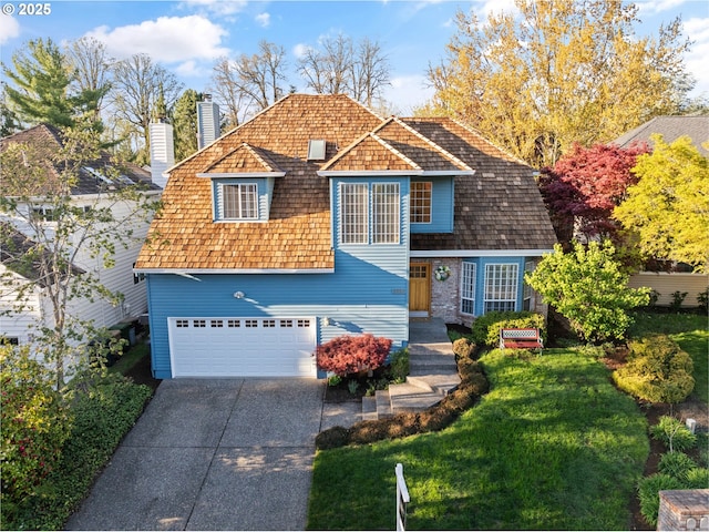 split level home featuring a front yard, an attached garage, a chimney, and driveway