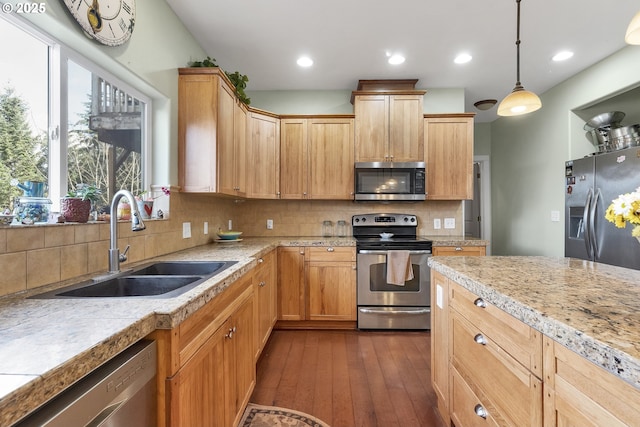 kitchen with sink, dark hardwood / wood-style flooring, pendant lighting, stainless steel appliances, and decorative backsplash