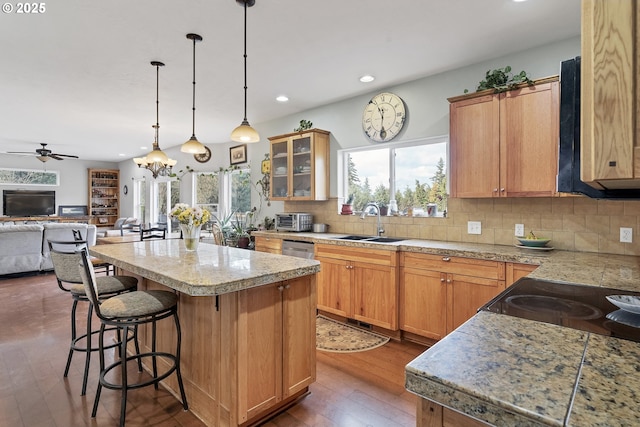 kitchen with tasteful backsplash, a breakfast bar area, a center island, and sink