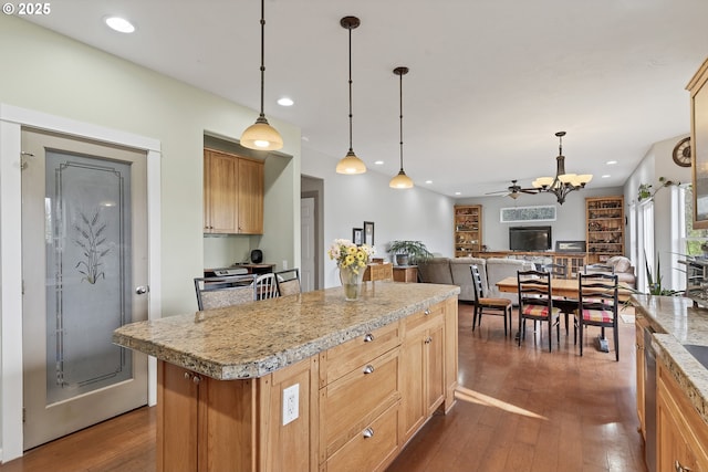 kitchen featuring hanging light fixtures, dark wood-type flooring, ceiling fan, and a kitchen island