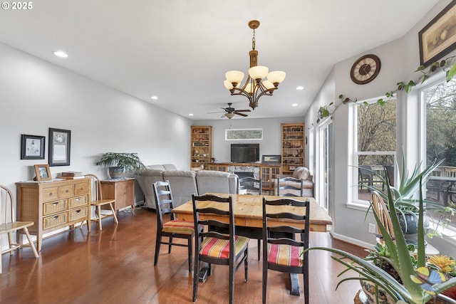 dining room featuring dark hardwood / wood-style flooring and ceiling fan with notable chandelier