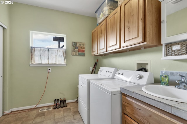 laundry area featuring cabinets, separate washer and dryer, and sink