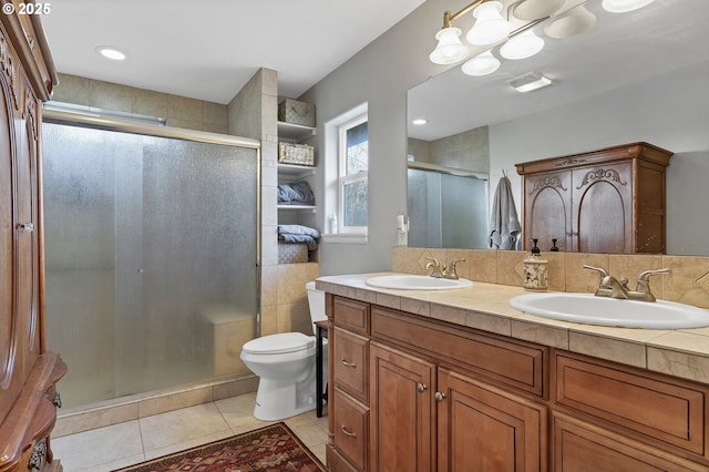 bathroom featuring tile patterned flooring, an enclosed shower, vanity, and toilet