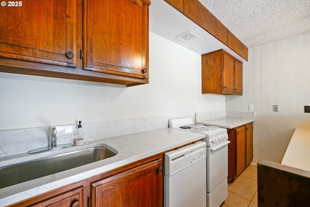 3457 Champlain Ct, Salem, OR 97304 - kitchen with white dishwasher, range, a textured ceiling, brown cabinetry, and a sink