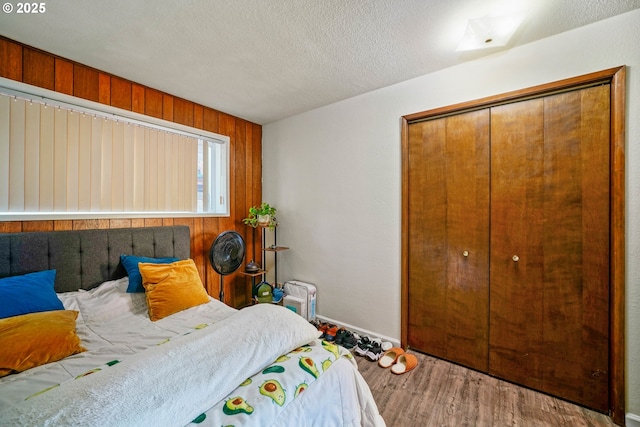 3457 Champlain Ct, Salem, OR 97304 - bedroom with wood finished floors, a closet, a textured ceiling, baseboards, and wooden walls
