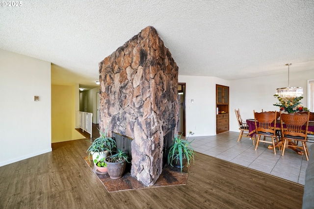 3457 Champlain Ct, Salem, OR 97304 - interior space featuring baseboards, an inviting chandelier, a textured ceiling, and wood finished floors