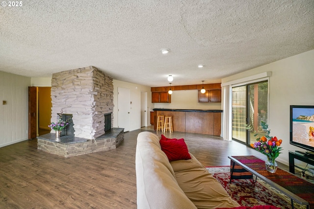 3457 Champlain Ct, Salem, OR 97304 - living room featuring a fireplace, a textured ceiling, baseboards, and dark wood finished floors