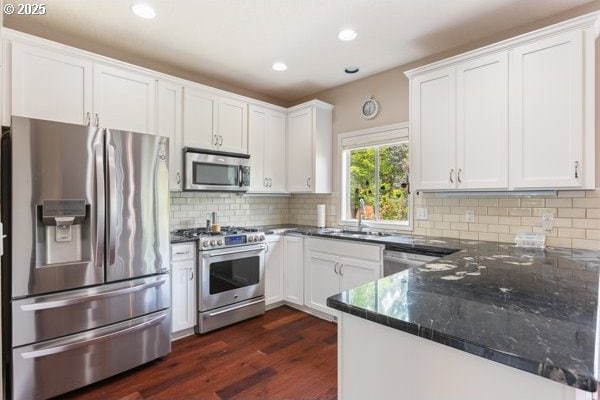 15395 SW Emerald St, Beaverton, OR 97007 - kitchen with stainless steel appliances, a sink, white cabinets, dark wood-style floors, and dark stone counters