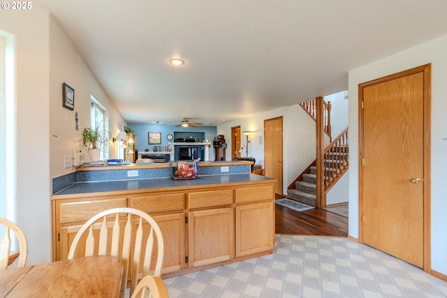 428 SE 11th Cir, Troutdale, OR 97060 - kitchen with a fireplace, a peninsula, dark countertops, open floor plan, and ceiling fan