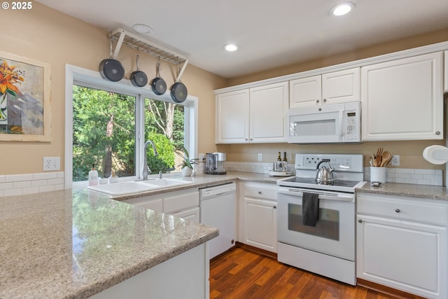 kitchen featuring dark wood-type flooring, a sink, recessed lighting, white appliances, and white cabinets