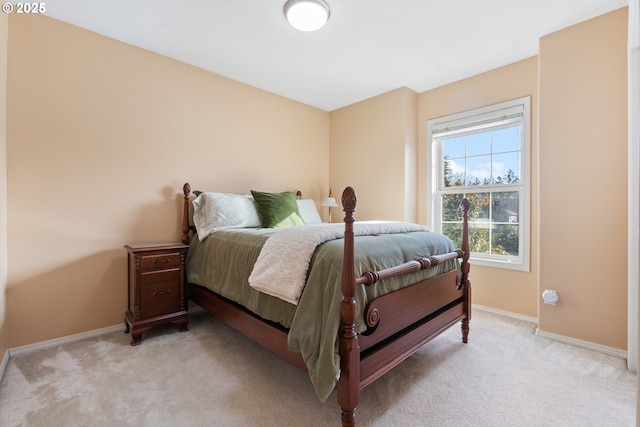 bedroom featuring light colored carpet and baseboards