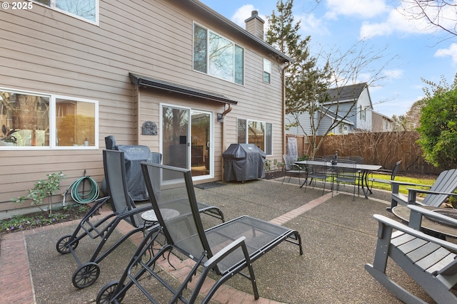 view of patio featuring outdoor dining area, a grill, and fence