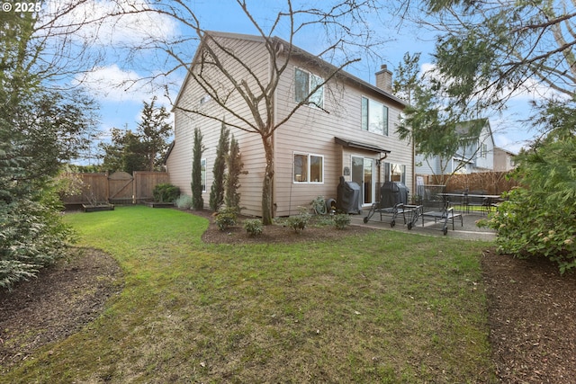 back of property featuring a patio area, a lawn, a chimney, and a fenced backyard