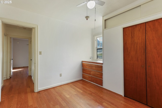 unfurnished bedroom featuring wood-type flooring, a closet, and ceiling fan