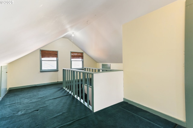 additional living space with lofted ceiling and dark colored carpet