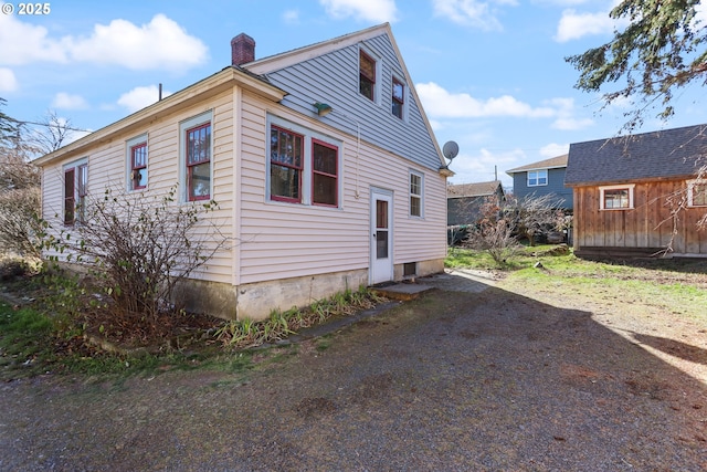 view of side of home featuring a storage shed