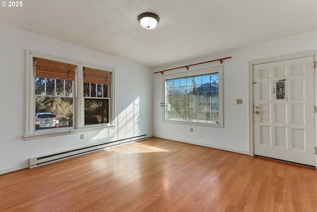 foyer entrance with light hardwood / wood-style flooring and baseboard heating