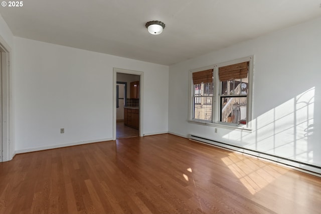 spare room with hardwood / wood-style flooring and baseboard heating