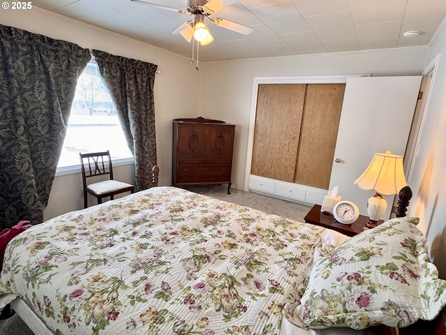 bedroom featuring crown molding, carpet floors, ceiling fan, and a closet