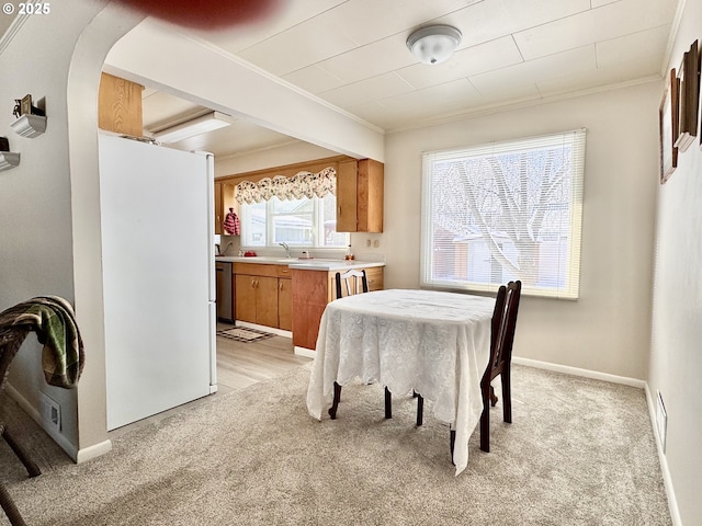 carpeted dining area with ornamental molding