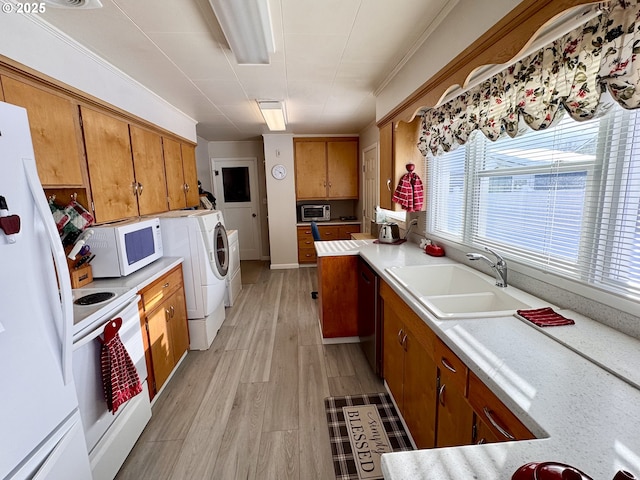 kitchen with washer / dryer, sink, white appliances, and light hardwood / wood-style flooring