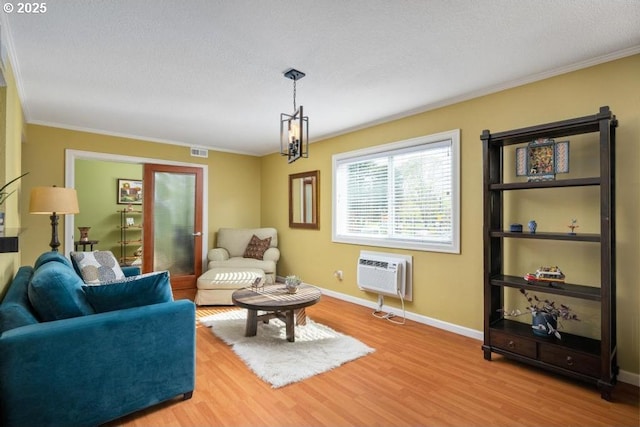 6600 SE Division St Unit 304, Portland, OR 97206 - living area featuring crown molding, visible vents, a wall unit AC, and wood finished floors