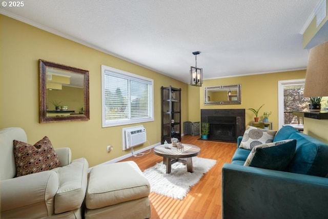 6600 SE Division St Unit 304, Portland, OR 97206 - living area with crown molding, a fireplace with flush hearth, a wall unit AC, and wood finished floors