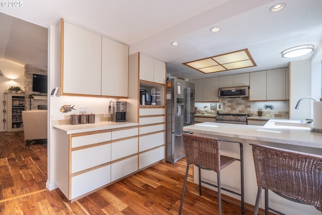 5 Woodthrush Ln, Gleneden Beach, OR 97388 - kitchen with appliances with stainless steel finishes, a sink, wood finished floors, decorative backsplash, and light countertops