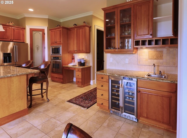 kitchen featuring beverage cooler, a breakfast bar area, appliances with stainless steel finishes, a sink, and backsplash