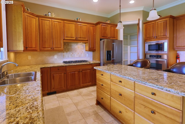 kitchen with appliances with stainless steel finishes, pendant lighting, a sink, and backsplash