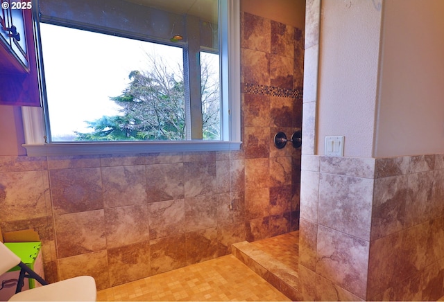 full bath featuring a wealth of natural light, tile walls, and walk in shower