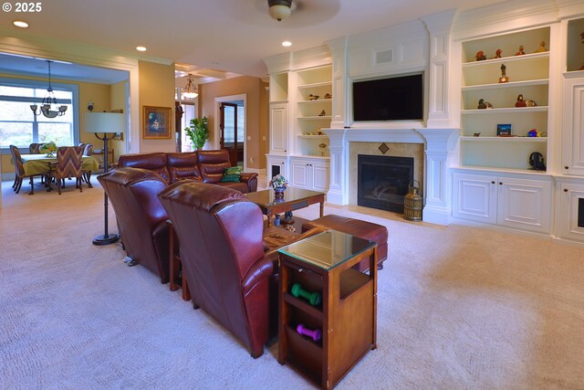 living room with recessed lighting, light colored carpet, a fireplace with flush hearth, built in features, and an inviting chandelier