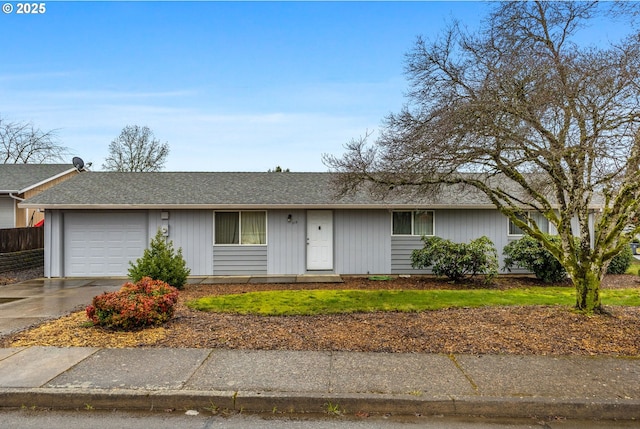 ranch-style home featuring a garage, driveway, a shingled roof, and fence